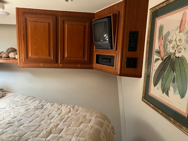 Slide: The Image of Interior of 1995 Viking Sports Yacht with wood cabinets, vintage TV, and floral artwork. - 40