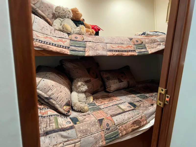 Slide: The Image of Bunk beds with patterned bedding and teddy bears on a 1995 Viking Sports Yacht. - 43