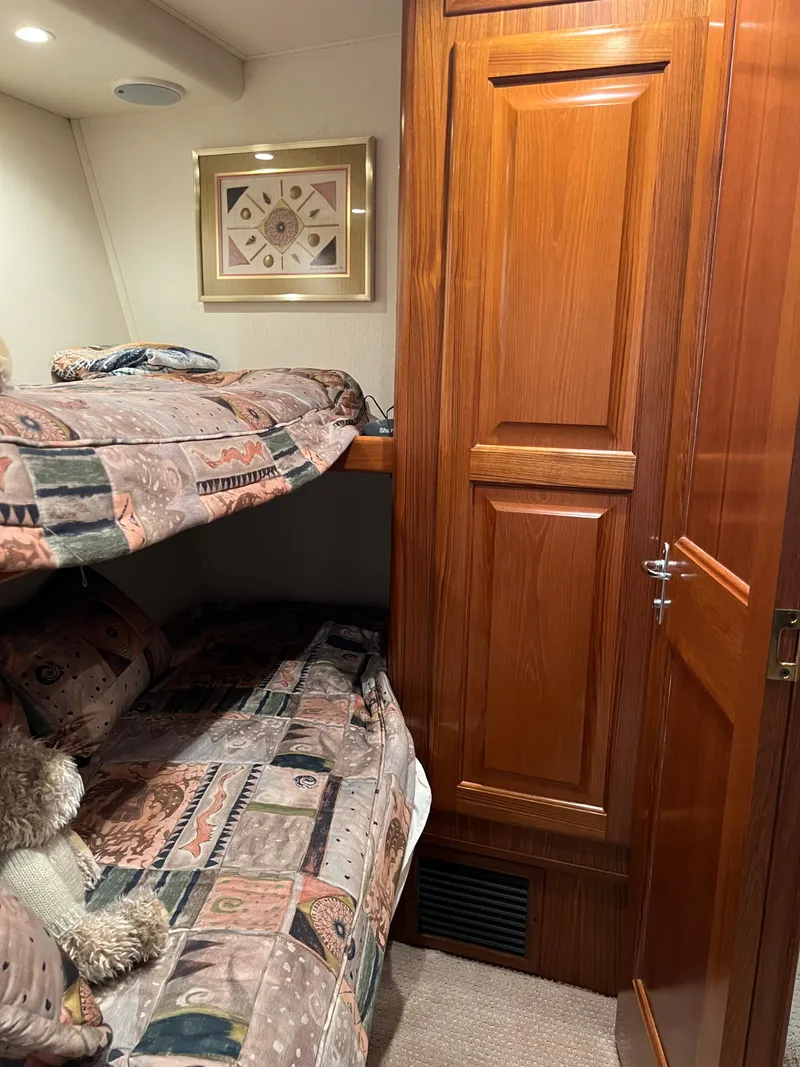 Slide: The Image of Cozy cabin interior of 1995 Viking Sports Yacht with wooden paneling and bunk beds. - 44