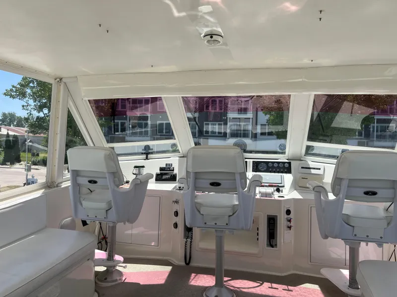 Slide: The Image of Interior of a 1995 Viking Sports Yacht cockpit with three white captain chairs. - 49