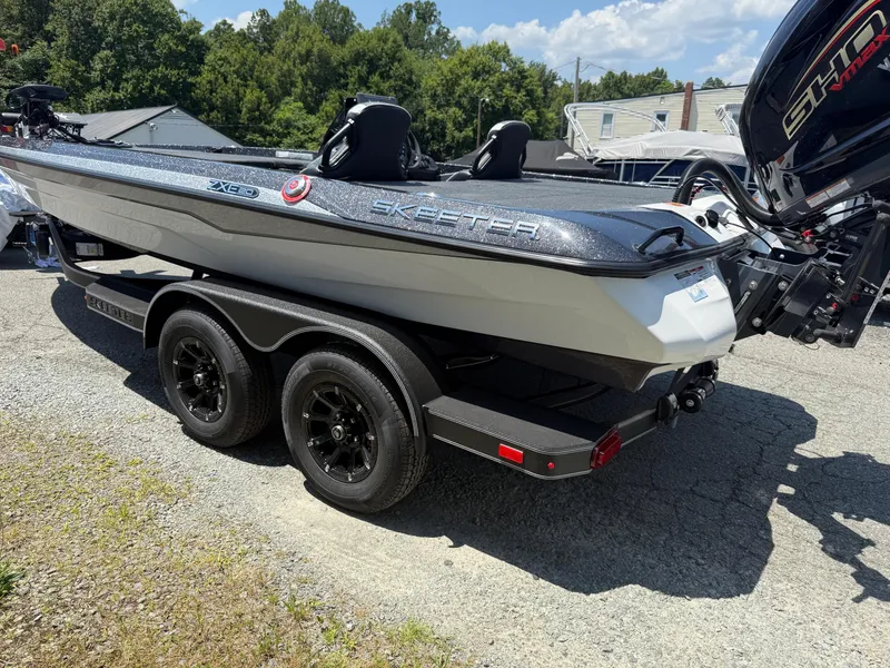 Slide: The Image of 2026 Skeeter ZXE20 boat on trailer, parked outdoors, with trees in background. - 29