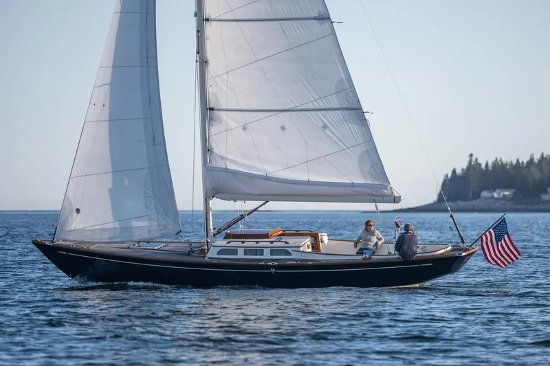 Slide: The Image of Sailing on a 2006 Morris M36 Daysailer with American flag, calm waters, and distant shoreline. - 1