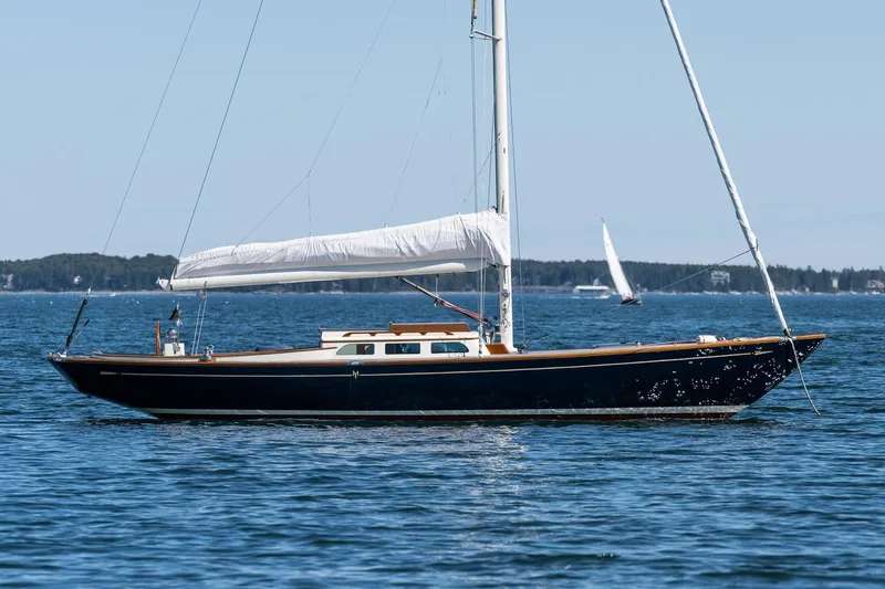 Slide: The Image of 2006 Morris M36 Daysailer on calm blue water, elegant design, white sails, clear sky. - 12