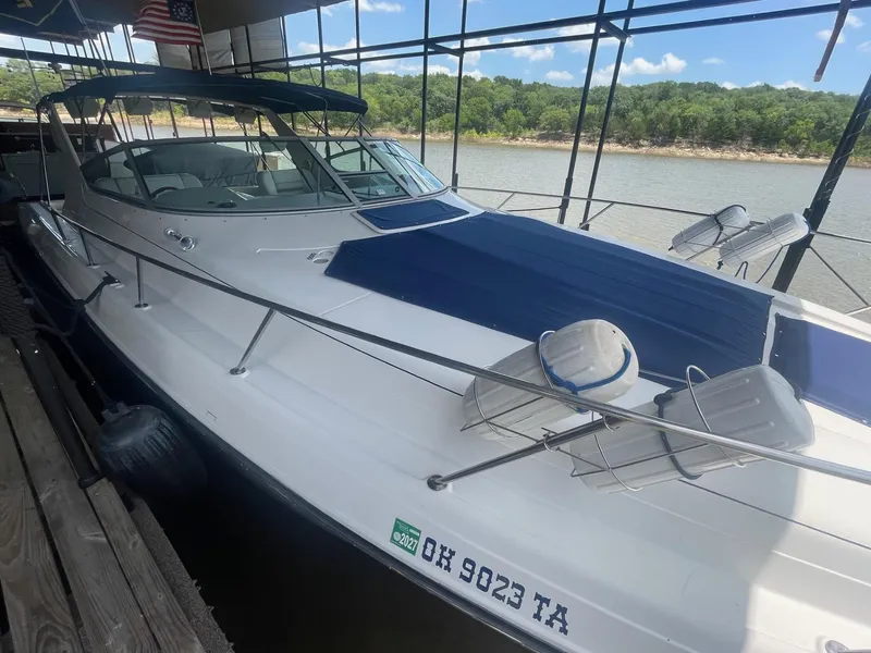 The Image of 1996 Regal Commodore 402 yacht docked by a scenic lake under a clear blue sky. - 0