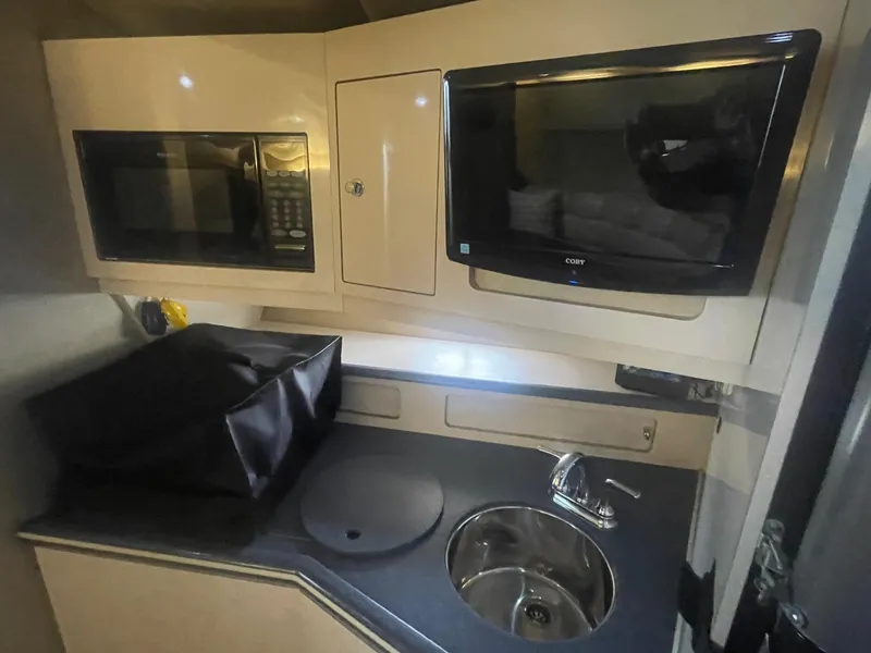 Slide: The Image of 1996 Regal Commodore 402 kitchen area with microwave, sink, and TV. - 15