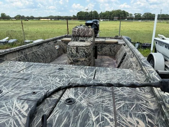 Slide: The Image of 2015 Ranger 1862 CC boat with camouflage design, parked outdoors near a field. - 5
