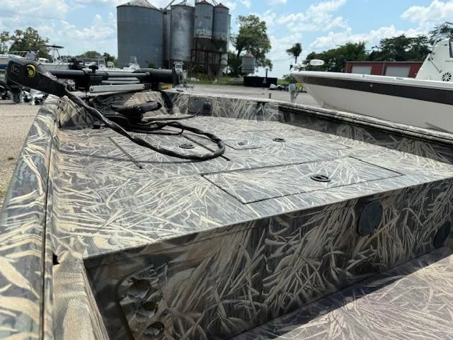 Slide: The Image of 2015 Ranger 1862 CC boat with camouflage design, docked near silos under a blue sky. - 6