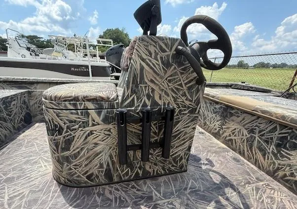 Slide: The Image of Camouflage-patterned 2015 Ranger 1862 CC boat console with rod holders under a sunny sky. - 7