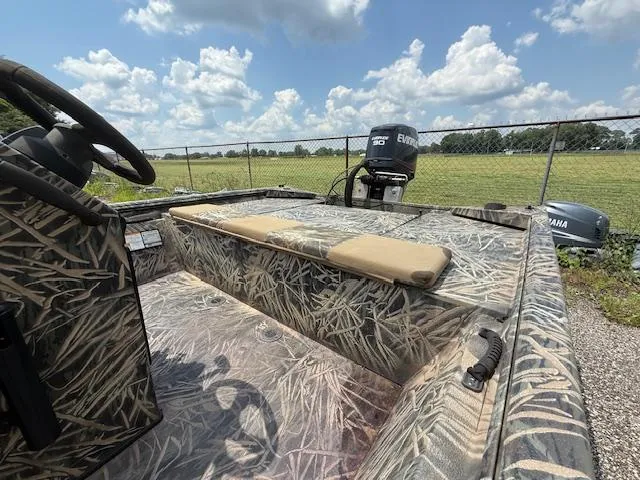 Slide: The Image of 2015 Ranger 1862 CC boat with camouflage design and Evinrude motor, parked outdoors. - 8