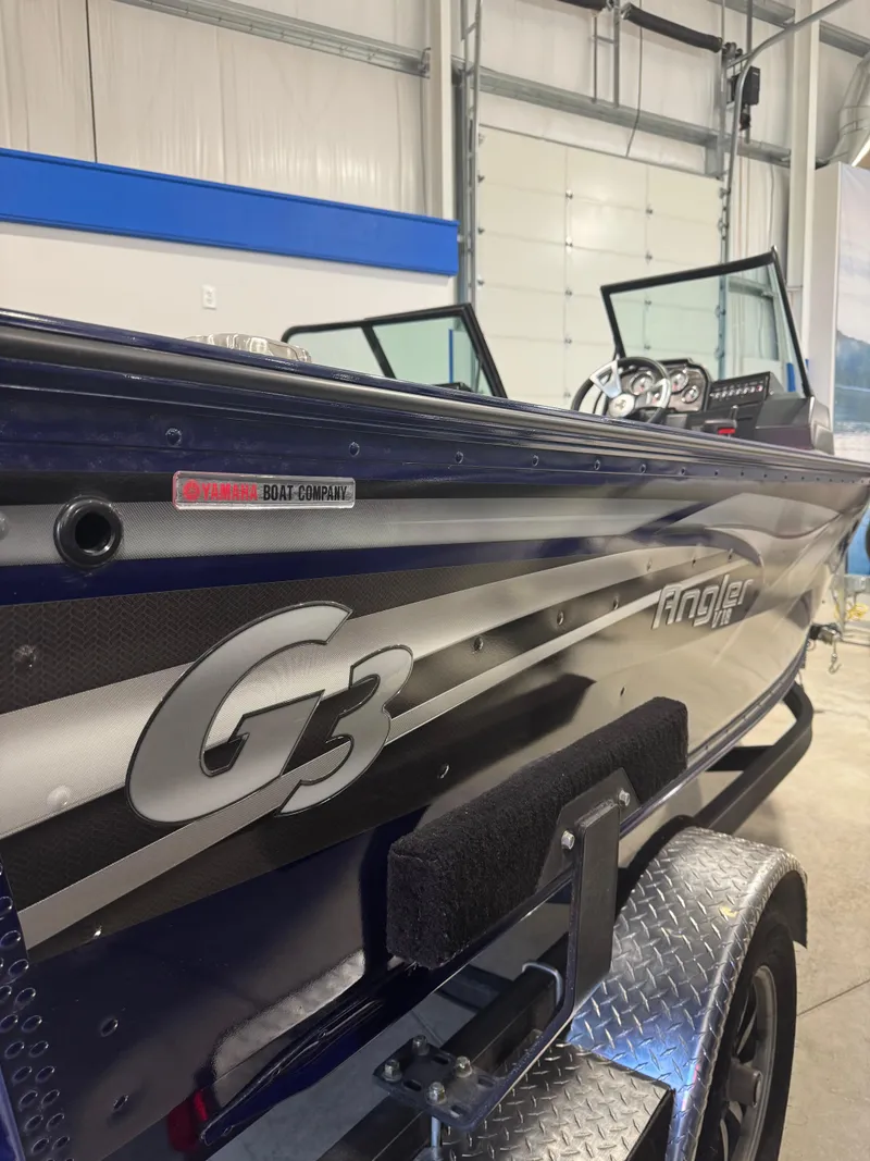 The Image of 2024 G3 AV18SF VINYL boat in showroom, featuring sleek design and Angler branding. - 1