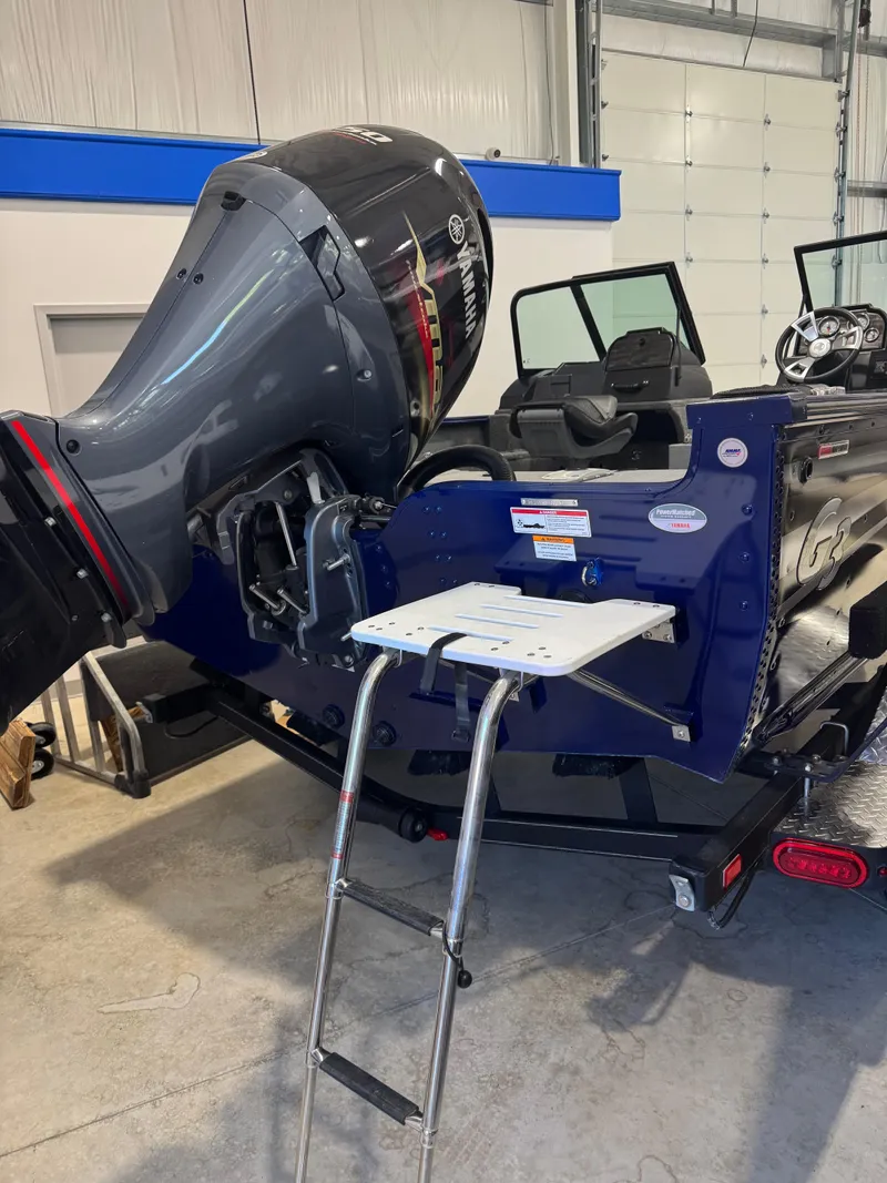 Slide: The Image of 2024 G3 AV18SF VINYL boat with Yamaha outboard motor and boarding ladder in a garage. - 3