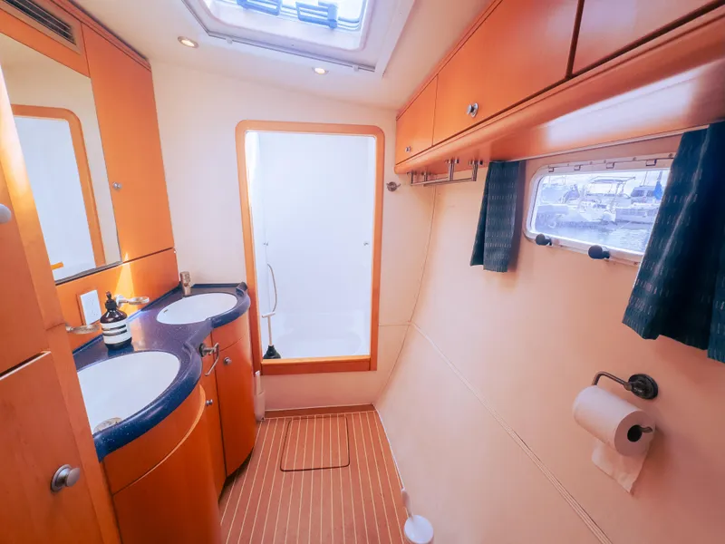 Slide: The Image of Luxurious yacht bathroom with dual sinks, wooden cabinetry, and a window view, 2005 model. - 11