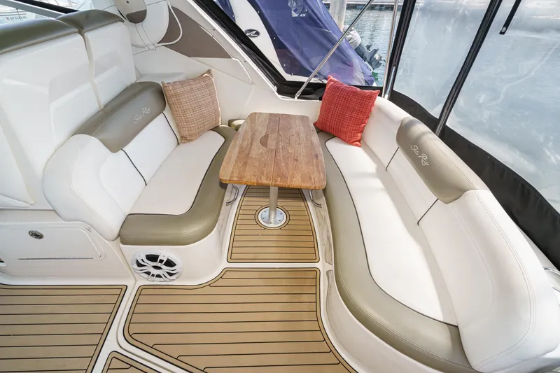 Slide: The Image of 2007 Sea Ray 310 Sundancer interior with cushioned seating and wooden table. - 11
