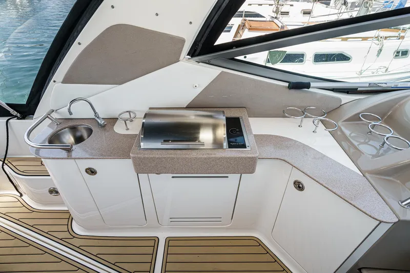 Slide: The Image of 2007 Sea Ray 310 Sundancer boat kitchenette with sink, grill, and cup holders. - 12