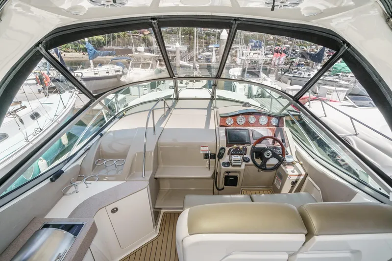 Slide: The Image of 2007 Sea Ray 310 Sundancer cockpit with helm, gauges, and marina view. - 14