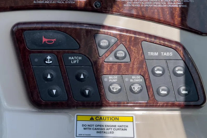 Slide: The Image of Control panel of a 2007 Sea Ray 310 Sundancer boat with various switches and caution label. - 19