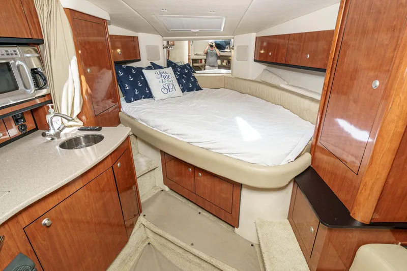 Slide: The Image of Luxurious 2007 Sea Ray 310 Sundancer cabin with bed, kitchenette, and wood cabinetry. - 24