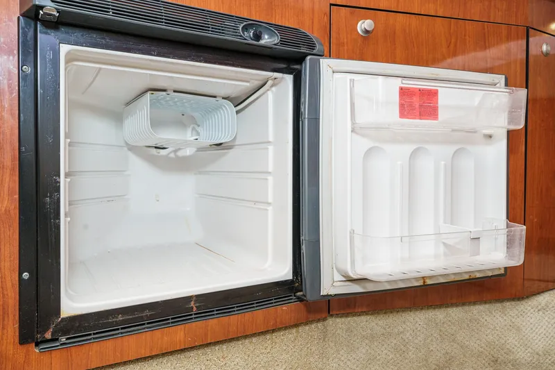 Slide: The Image of Open refrigerator inside 2007 Sea Ray 310 Sundancer yacht, featuring wooden cabinetry. - 29