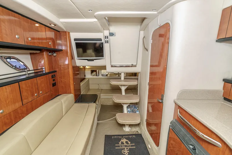Slide: The Image of Interior of 2007 Sea Ray 310 Sundancer yacht with modern amenities and wooden cabinetry. - 30
