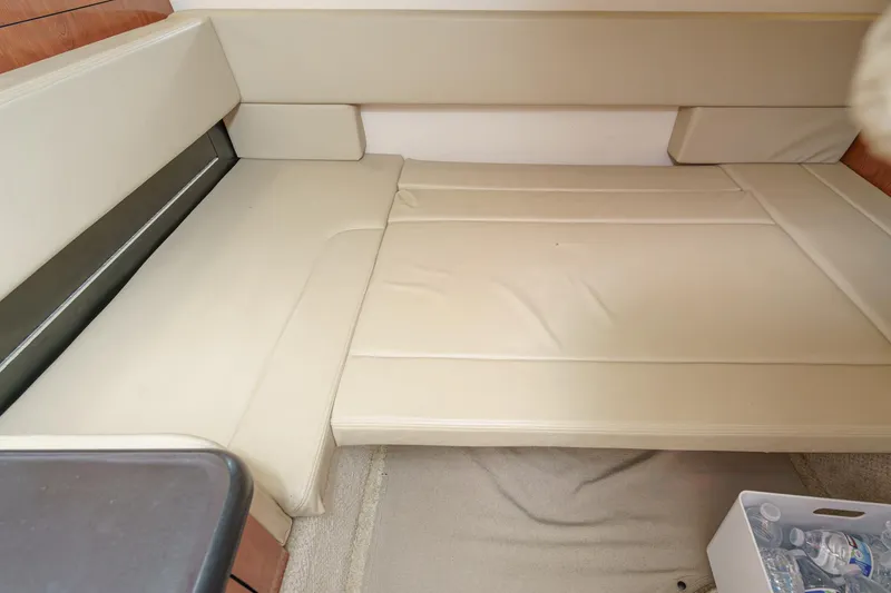 Slide: The Image of 2007 Sea Ray 310 Sundancer cabin interior with beige seating and storage area. - 34