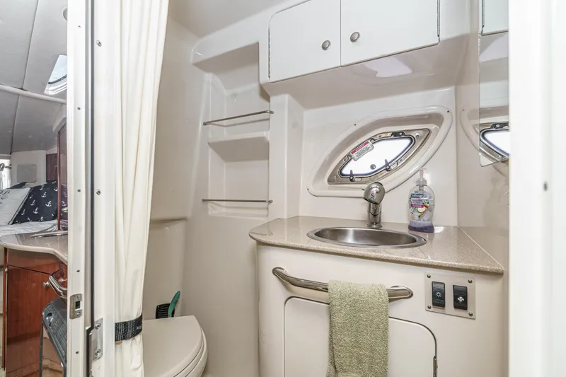 Slide: The Image of 2007 Sea Ray 310 Sundancer bathroom with sink, porthole, and storage cabinets. - 35