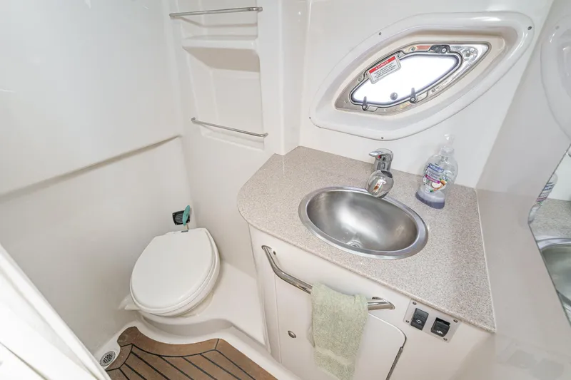 Slide: The Image of 2007 Sea Ray 310 Sundancer bathroom with sink, toilet, and porthole window. - 36