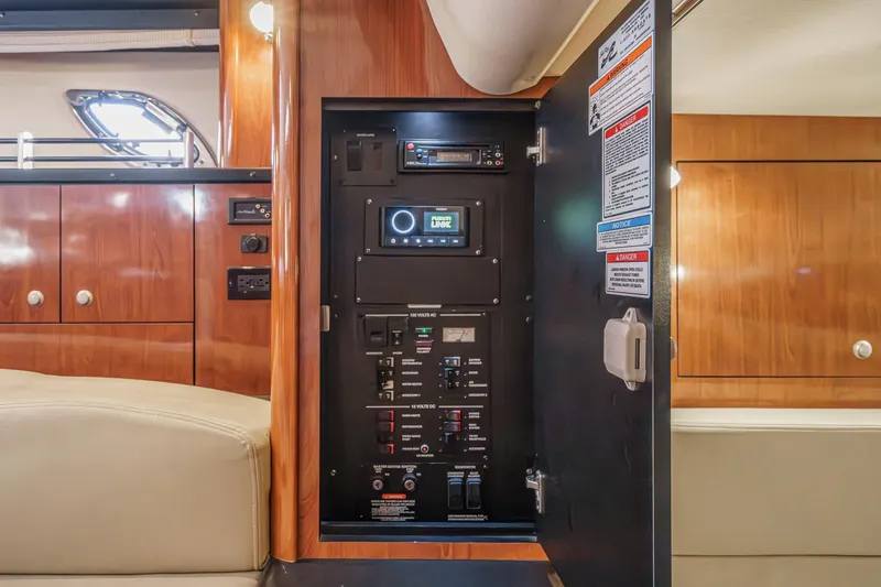 Slide: The Image of Electrical panel inside 2007 Sea Ray 310 Sundancer yacht, featuring wood cabinetry and modern controls. - 37