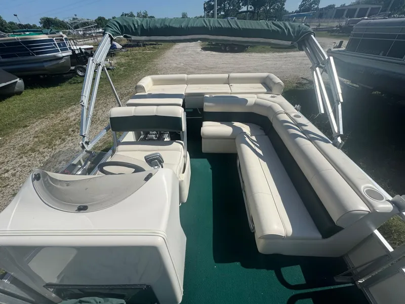 Slide: The Image of 2003 Odyssey MILLENIUM pontoon boat with spacious seating and canopy, parked on grass. - 2