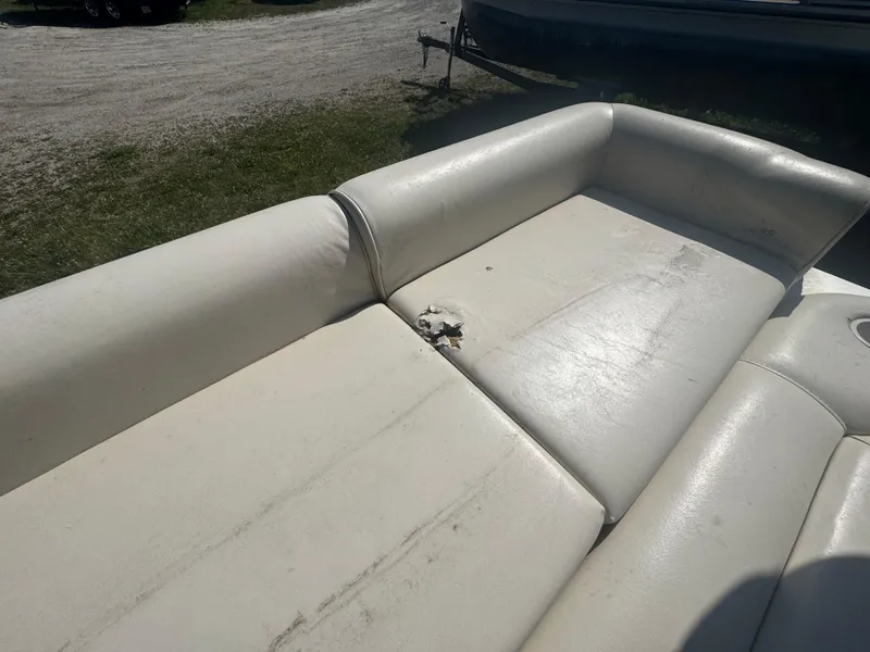 Slide: The Image of Worn white leather seat on 2003 Odyssey MILLENIUM boat, showing damage and outdoor setting. - 6