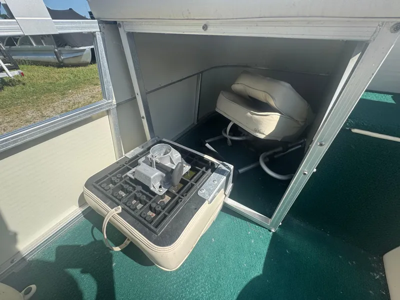 Slide: The Image of 2003 Odyssey MILLENIUM boat interior with storage compartment and folded seat on green carpet. - 7