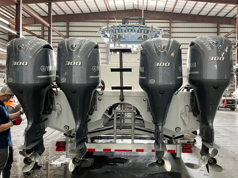 Slide: The Image of Four Yamaha 300 outboard motors on a 2017 Freeman 37 VH boat in a warehouse. - 2
