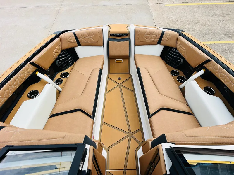 Slide: The Image of 2026 Nautique Super Air Nautique G25 Paragon interior with luxurious tan seating and cup holders. - 10