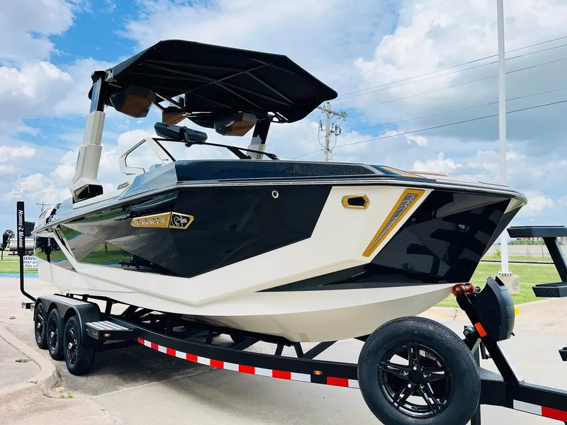Slide: The Image of 2026 Nautique Super Air Nautique G25 Paragon boat on trailer under blue sky. - 2