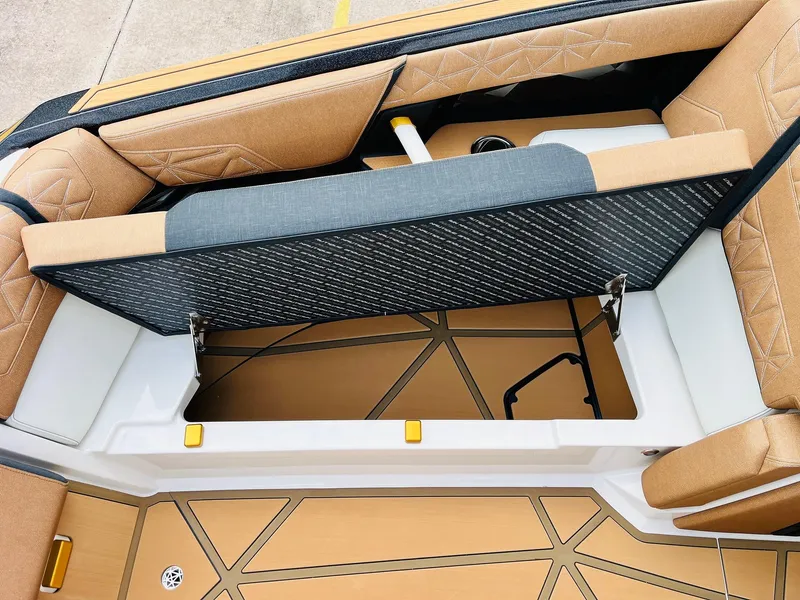 Slide: The Image of 2026 Nautique Super Air Nautique G25 Paragon interior storage compartment with tan upholstery. - 20