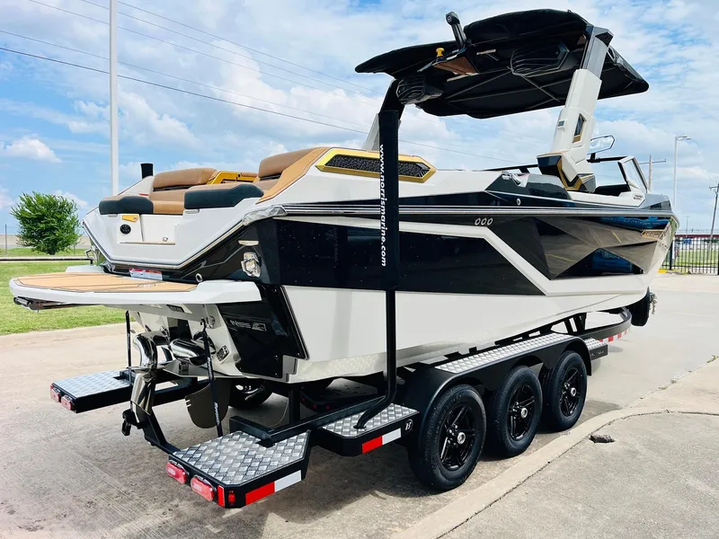 Slide: The Image of 2026 Nautique Super Air Nautique G25 Paragon boat on trailer, sleek design, sunny day. - 4
