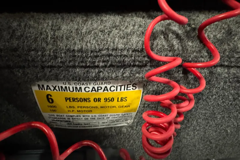 Slide: The Image of 2010 Lund 1825 Explorer boat capacity label, 6 persons or 950 lbs, with red coiled cable. - 14