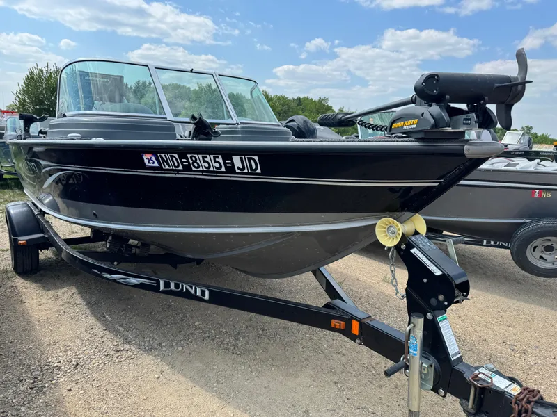 Slide: The Image of 2010 Lund 1825 Explorer boat on trailer in a warehouse setting. - 2