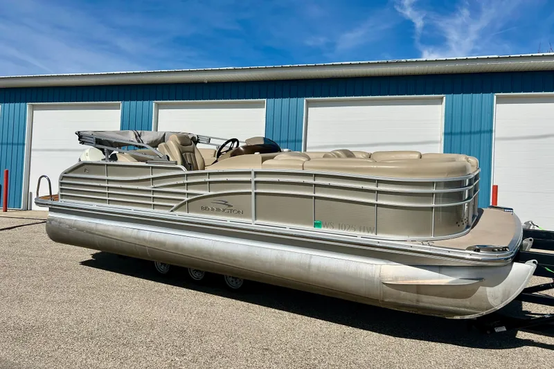 The Image of 2012 Bennington 2250RCL pontoon boat parked near blue building. - 0