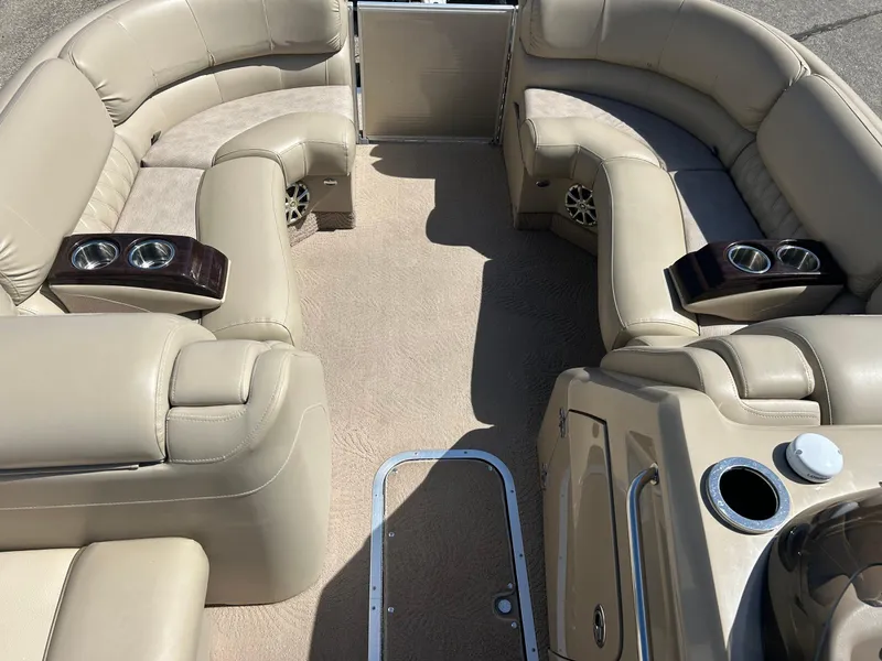 Slide: The Image of Luxurious interior of a 2012 Bennington 2250RCL pontoon boat with beige seating and cup holders. - 11