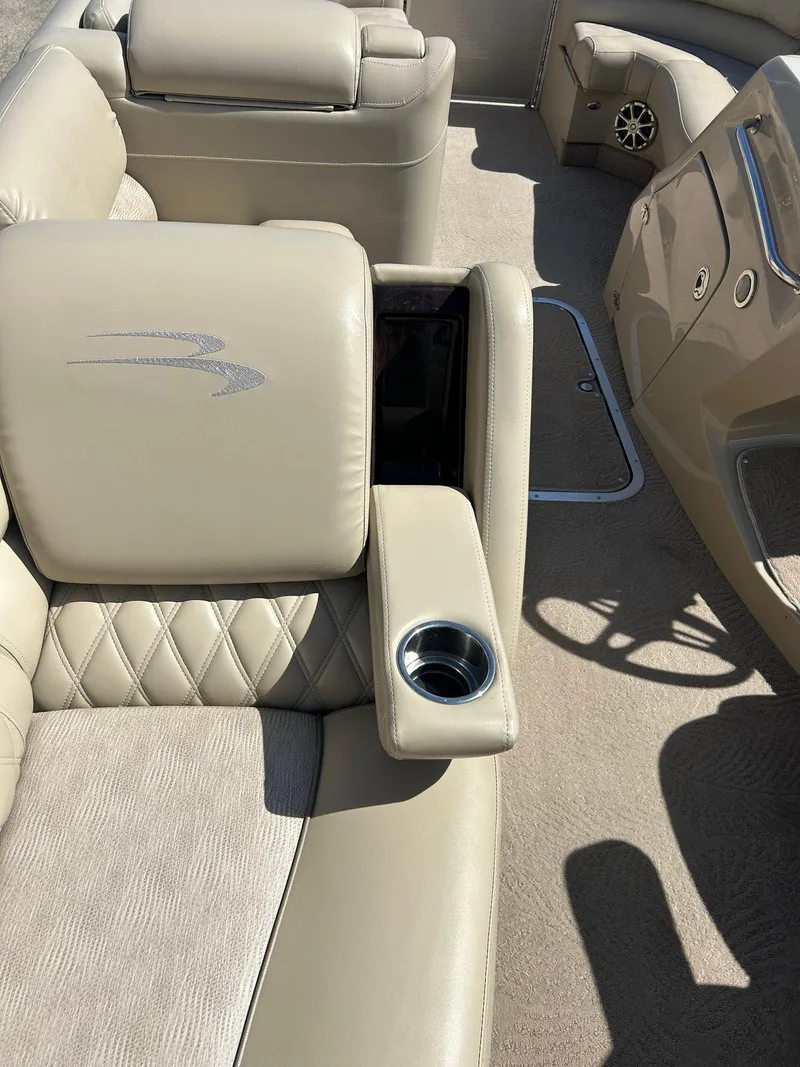 Slide: The Image of 2012 Bennington 2250RCL boat interior with beige seating and cup holder. - 17