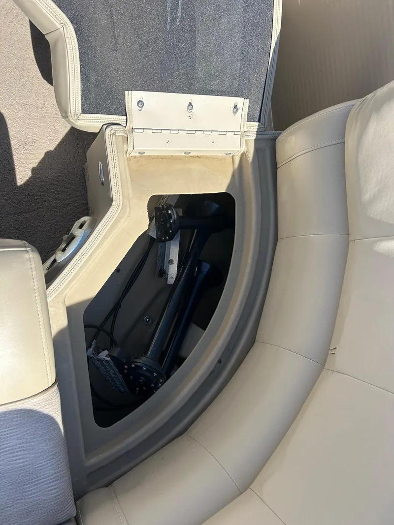 Slide: The Image of 2012 Bennington 2250RCL boat storage compartment with beige seating and visible hinge. - 22
