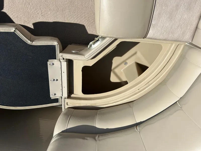 Slide: The Image of 2012 Bennington 2250RCL boat storage compartment with open cushioned seat and hinge detail. - 23