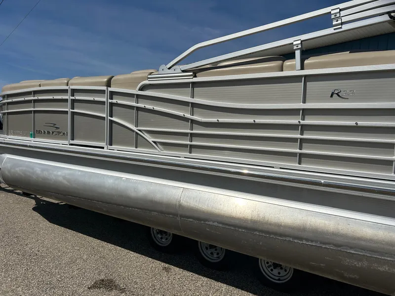 Slide: The Image of 2012 Bennington 2250RCL pontoon boat with sleek aluminum design under clear blue sky. - 40