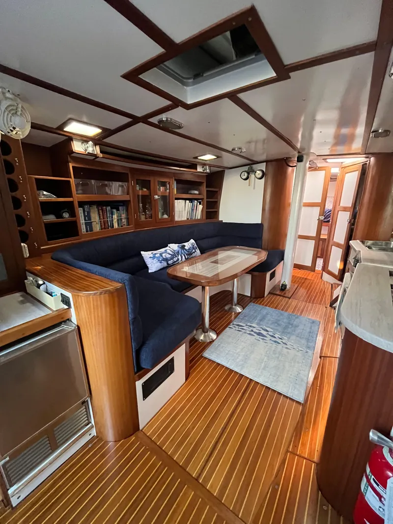Slide: The Image of Interior of 1976 Frers Custom yacht with wooden flooring and blue seating. - 13