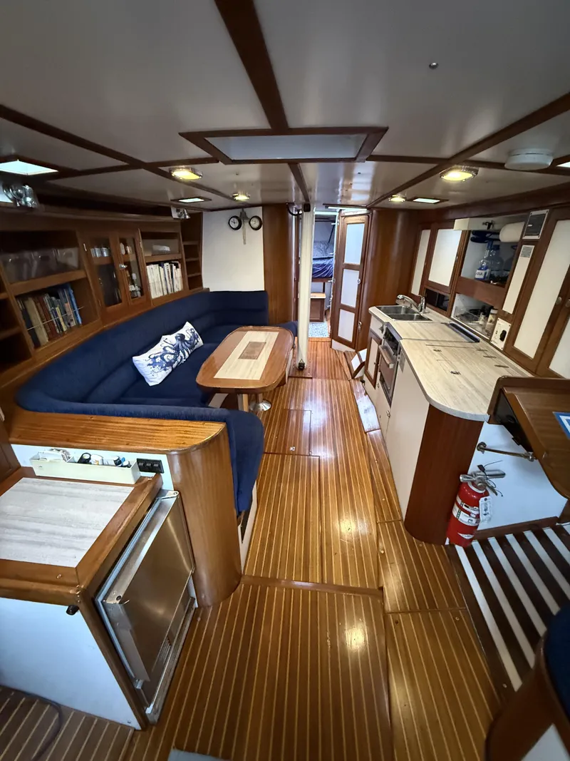 Slide: The Image of Interior of 1976 Frers Custom yacht with wooden flooring and cozy seating area. - 14