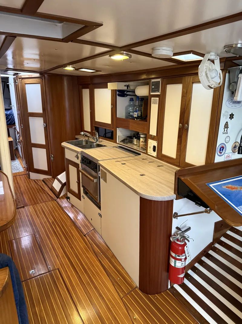 Slide: The Image of 1976 Frers Custom yacht interior with wooden flooring and modern kitchen amenities. - 17