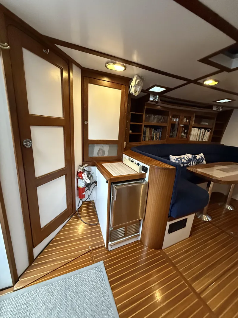 Slide: The Image of Interior of 1976 Frers Custom yacht with wood paneling, seating, and compact kitchen area. - 20