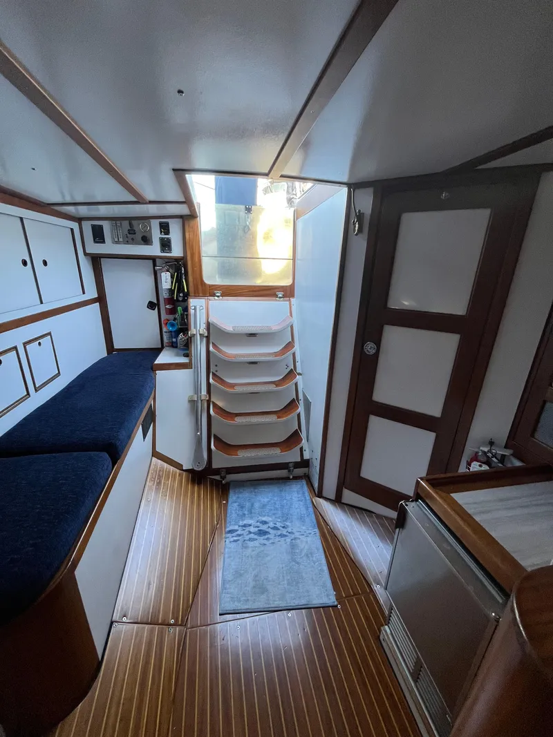 Slide: The Image of Interior of 1976 Frers Custom yacht with wooden flooring and white cabinetry. - 24