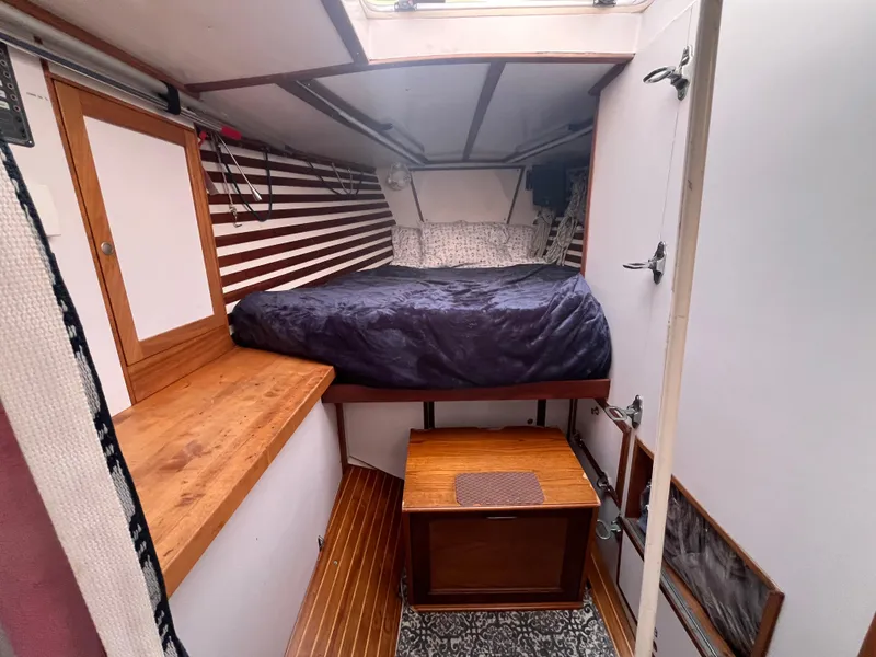 Slide: The Image of 1976 Frers Custom yacht interior with cozy bed, wooden accents, and striped walls. - 25