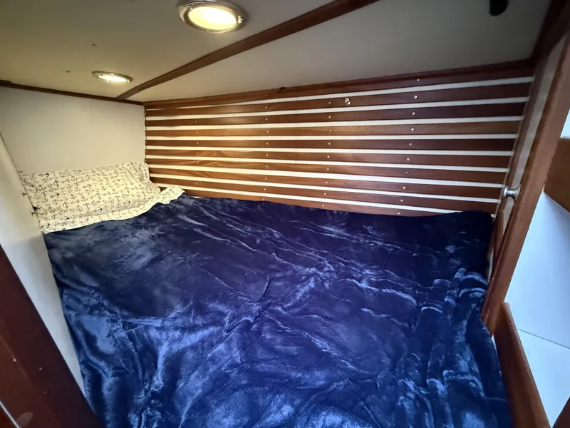 Slide: The Image of Cozy cabin bed in 1976 Frers Custom yacht with nautical-themed bedding. - 27